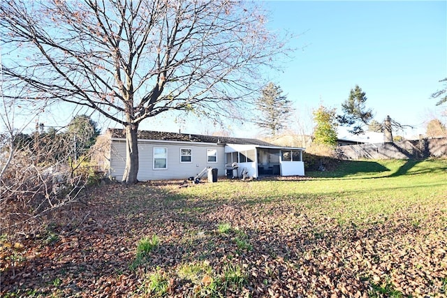 back of property with a yard and a sunroom