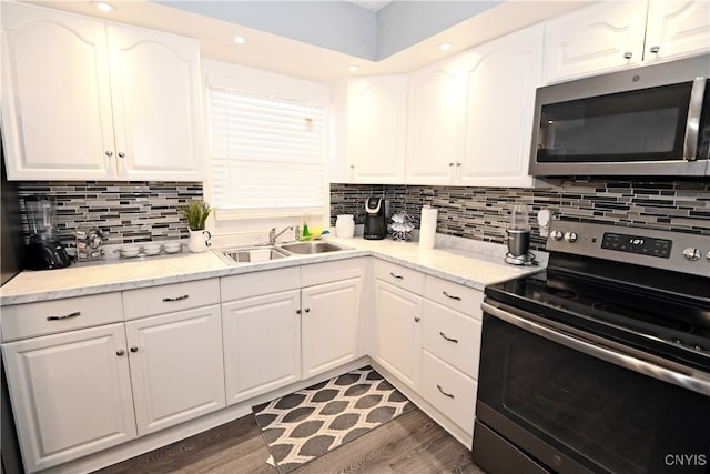 kitchen featuring stainless steel appliances, white cabinetry, dark hardwood / wood-style floors, and sink