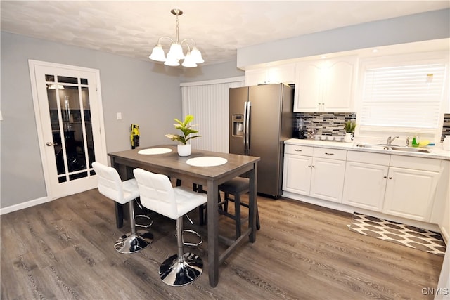 dining area featuring a notable chandelier, dark wood-type flooring, and sink