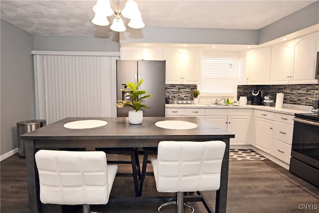 kitchen with backsplash, white cabinets, sink, dark hardwood / wood-style floors, and stainless steel appliances