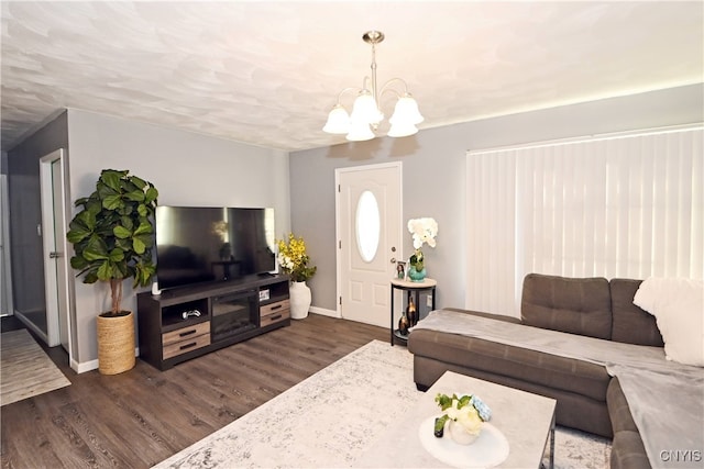 living room with dark hardwood / wood-style floors and a notable chandelier