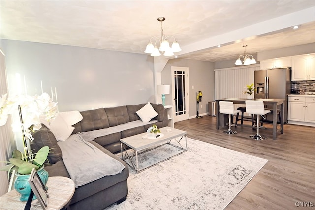 living room featuring wood-type flooring and an inviting chandelier