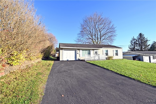 single story home featuring a front yard, a garage, and covered porch