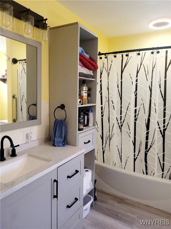 bathroom featuring shower / bath combination with curtain, vanity, and wood-type flooring