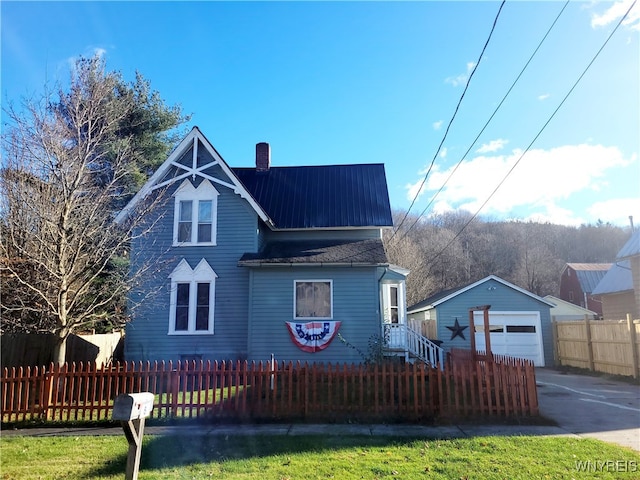 view of front of property with a garage and an outbuilding