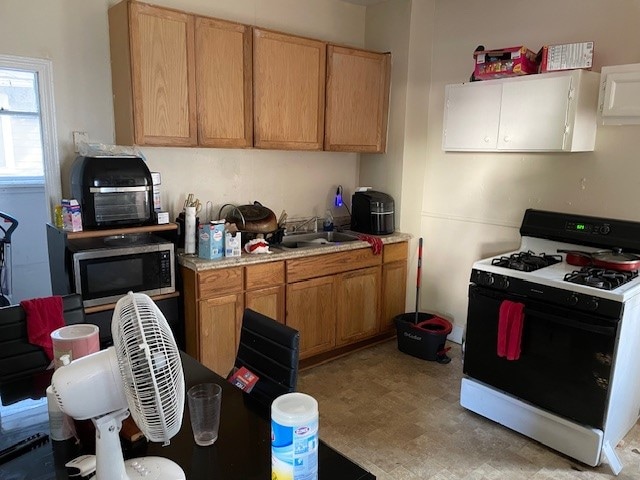 kitchen with white gas stove and sink