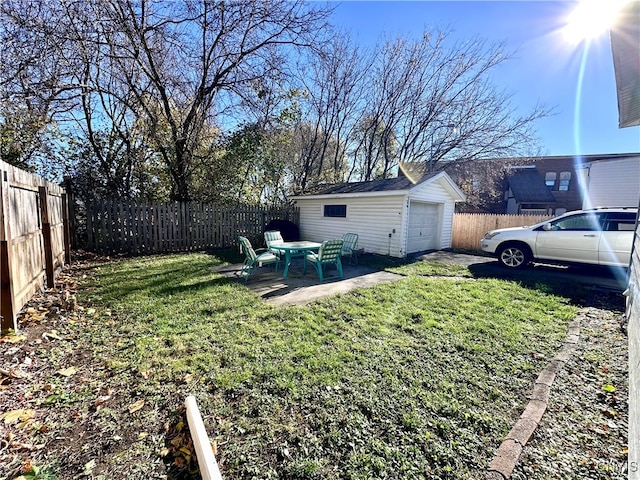 view of yard with a garage, a patio area, and an outdoor structure