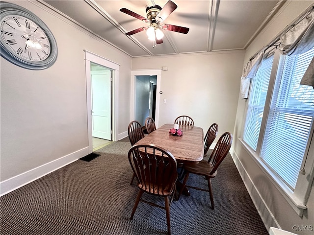 carpeted dining room featuring ceiling fan and crown molding