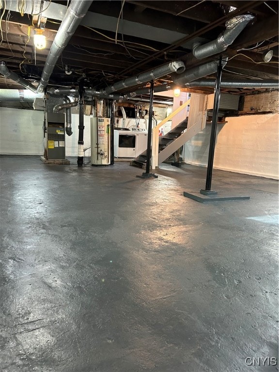 basement featuring heating unit, washer / clothes dryer, and water heater