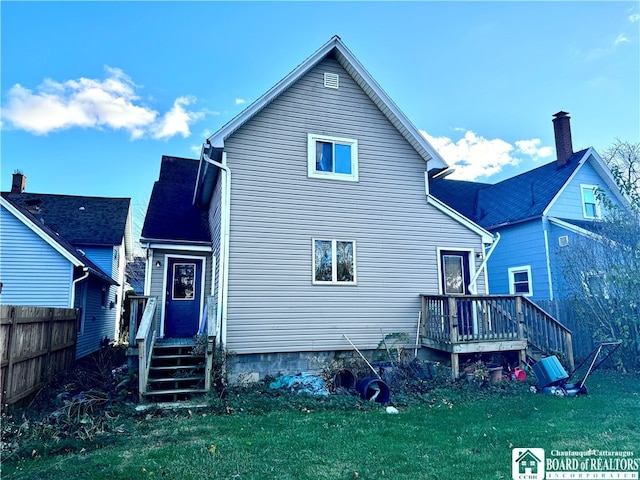 back of property featuring a lawn and a wooden deck