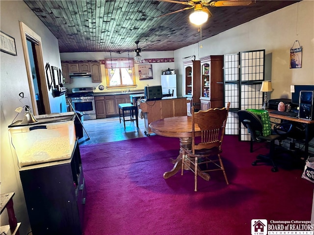 carpeted dining area with ceiling fan and lofted ceiling