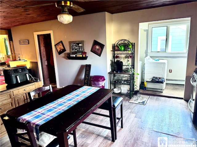 dining area with wood-type flooring, a baseboard radiator, and wooden ceiling