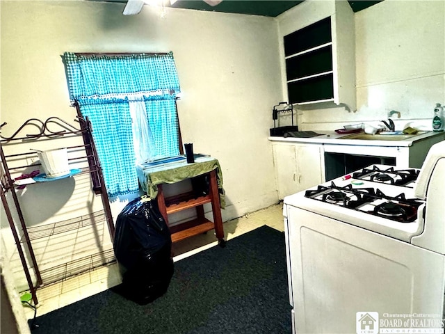 kitchen with white gas range oven and ceiling fan