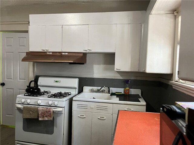 kitchen with white gas stove and white cabinets