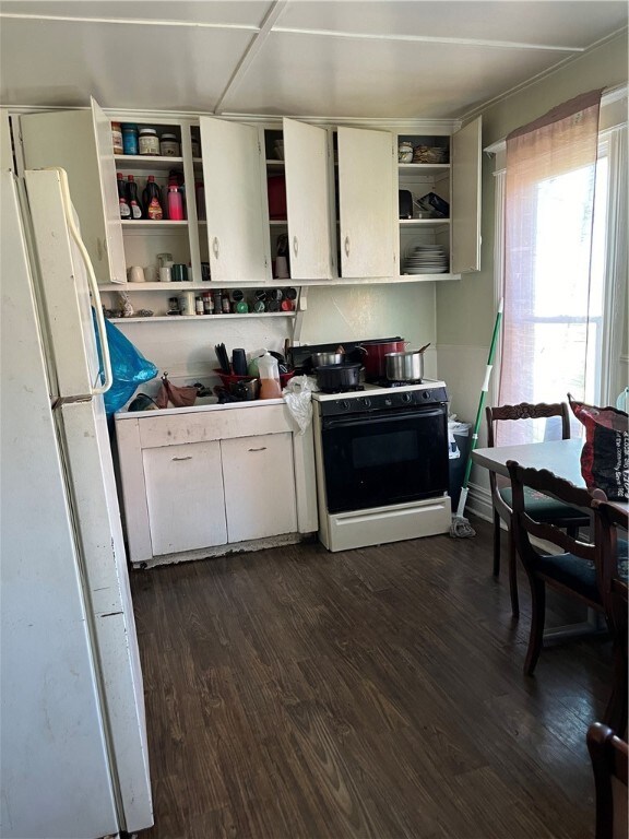 kitchen featuring white appliances, dark hardwood / wood-style floors, and white cabinetry