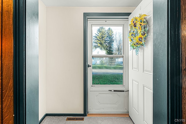 doorway to outside with light colored carpet