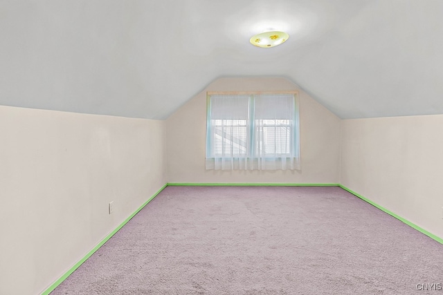 additional living space featuring light carpet and vaulted ceiling