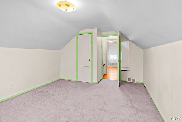 bonus room featuring lofted ceiling and light carpet