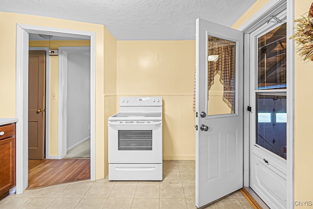 kitchen with white range with electric cooktop, light wood-type flooring, and a textured ceiling