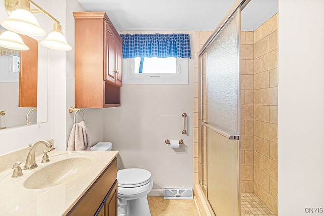 bathroom with tile patterned flooring, vanity, toilet, and walk in shower