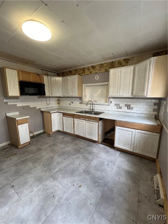 kitchen featuring decorative backsplash, light brown cabinetry, and sink