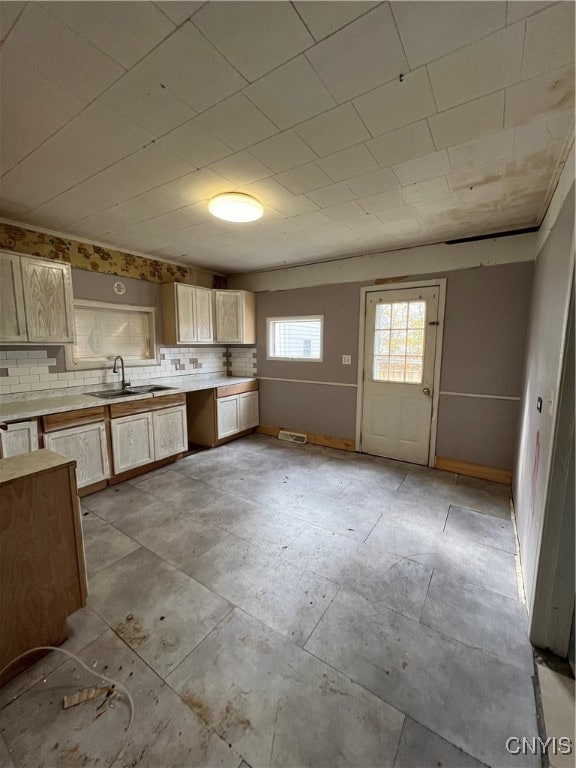 kitchen featuring tile countertops, decorative backsplash, sink, and light brown cabinetry