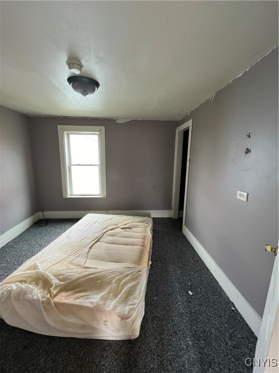 unfurnished bedroom featuring dark carpet