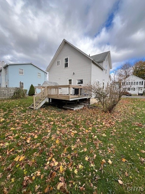 rear view of house with a yard and a wooden deck