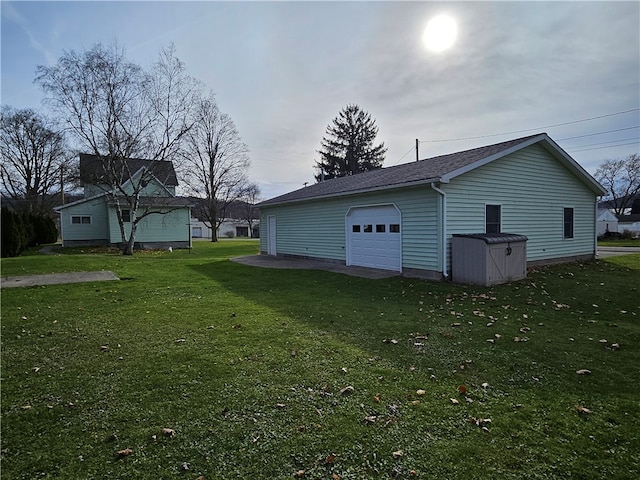 exterior space featuring a lawn, an outdoor structure, and a garage