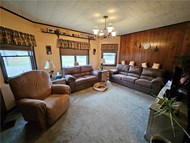 carpeted living room with a chandelier and wooden walls