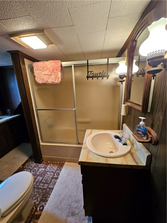 full bathroom featuring toilet, vanity, and combined bath / shower with glass door