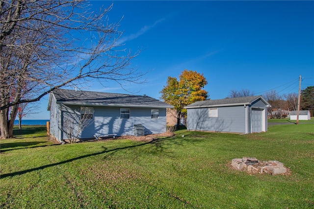 exterior space featuring a lawn, an outdoor structure, and a garage