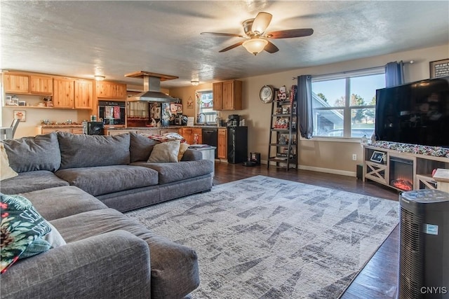 living room featuring a wealth of natural light, ceiling fan, dark wood-type flooring, and a textured ceiling