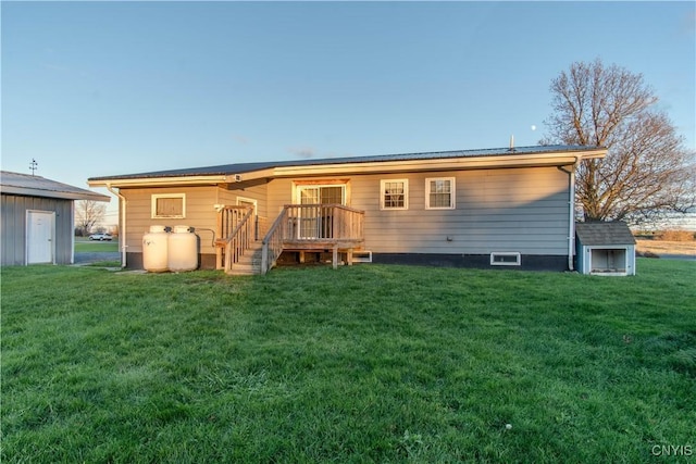 back of house with a storage shed, a yard, and a wooden deck