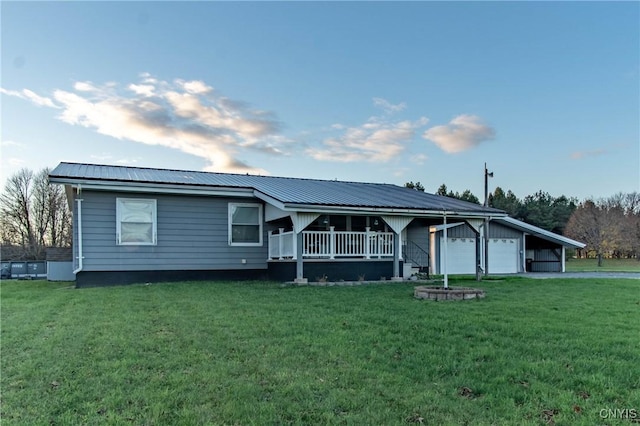 ranch-style home with covered porch, a front yard, and a garage