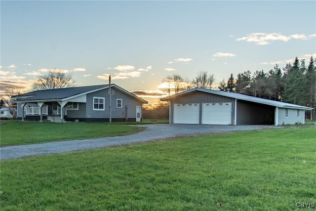 ranch-style house featuring a lawn, an outbuilding, and a garage