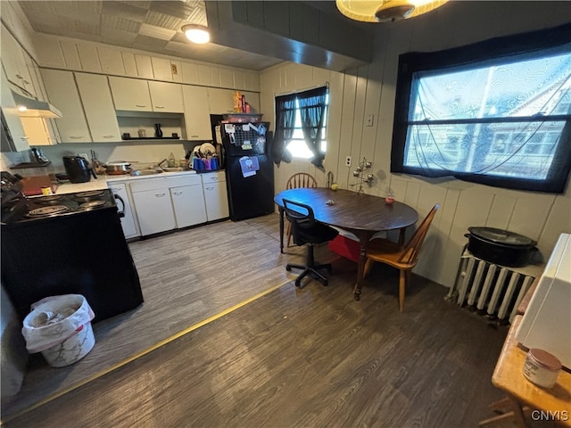 kitchen featuring sink, dark hardwood / wood-style floors, white cabinetry, and black appliances