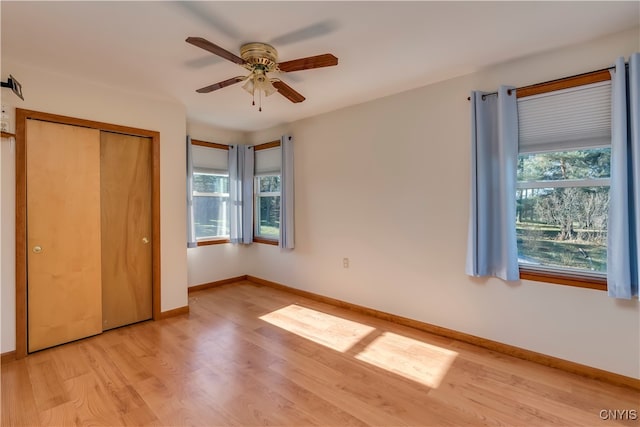 unfurnished bedroom with light hardwood / wood-style flooring, a closet, and ceiling fan