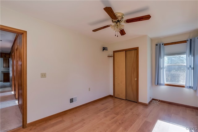 unfurnished bedroom with a closet, ceiling fan, and light wood-type flooring