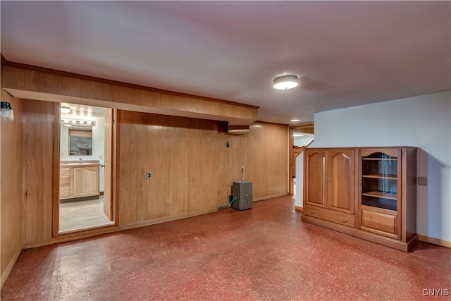 basement featuring sink and wood walls