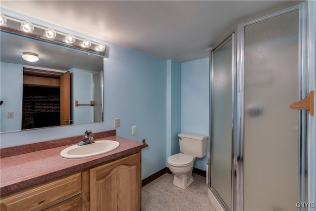 bathroom with vanity, a shower with door, and toilet