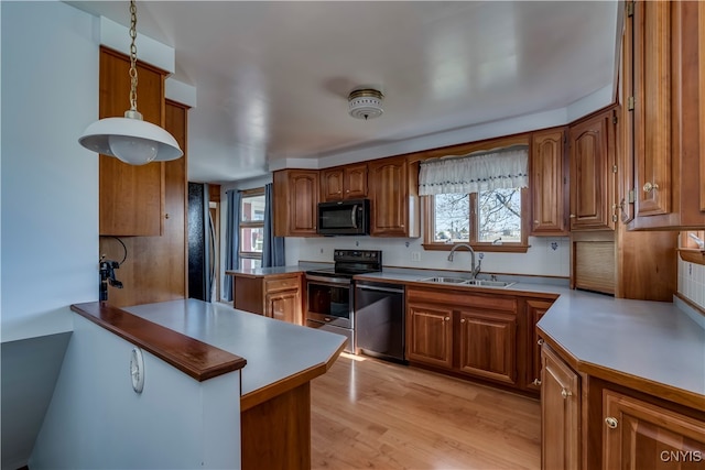 kitchen with sink, decorative light fixtures, electric range, dishwashing machine, and kitchen peninsula