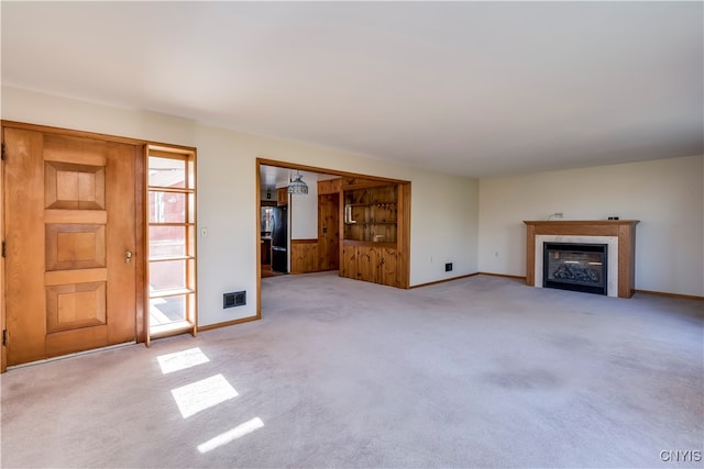 unfurnished living room featuring light carpet