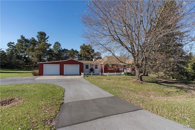 single story home featuring concrete driveway, a front yard, and a garage