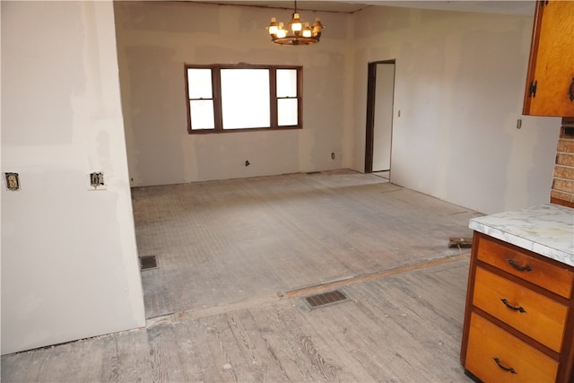 interior space with light hardwood / wood-style floors and an inviting chandelier