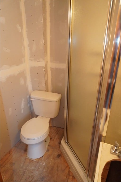 bathroom with an enclosed shower and toilet