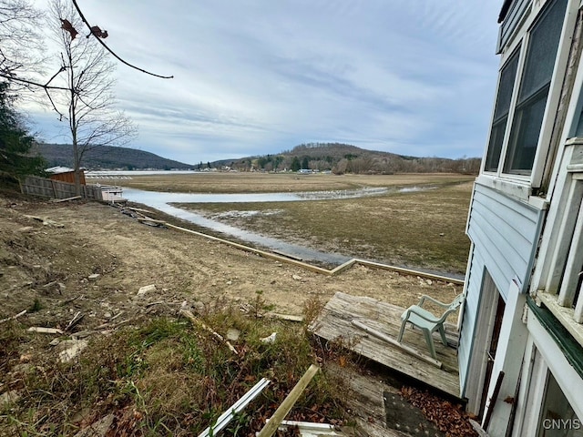 view of yard with a water and mountain view and a rural view