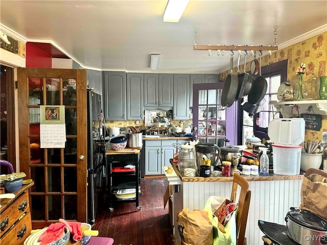 kitchen featuring gray cabinetry, crown molding, and dark hardwood / wood-style flooring