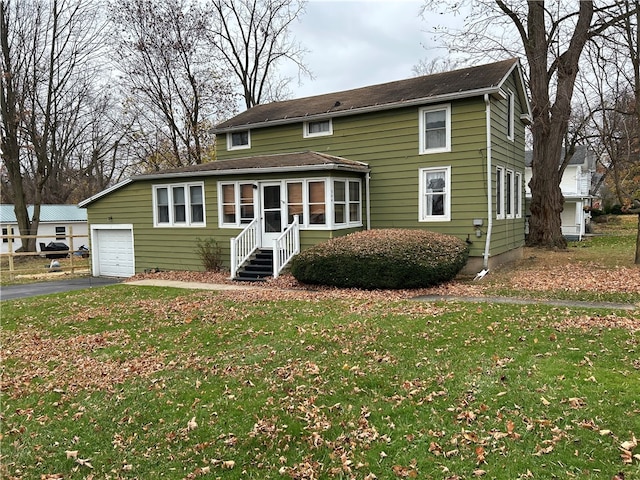 view of front of property with a front yard and a garage