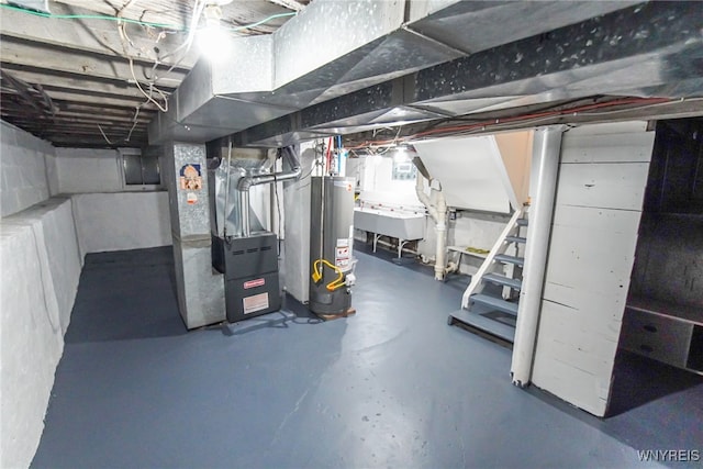 basement featuring gas water heater, heating unit, and sink